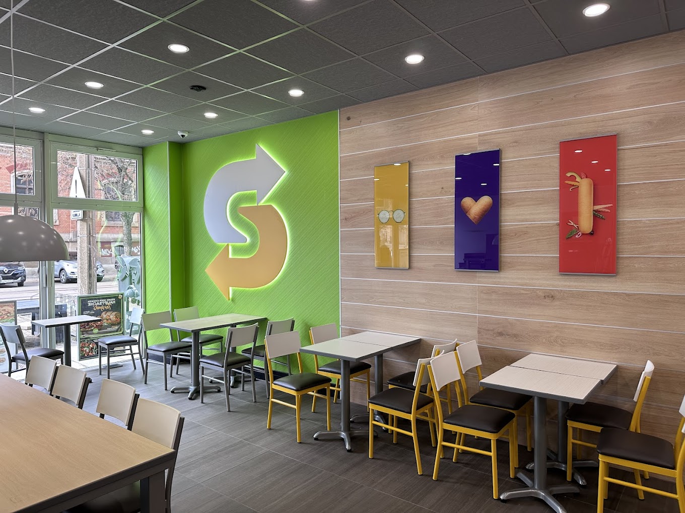 Innenraum des Subway-Restaurants mit grüner Logo-Wand