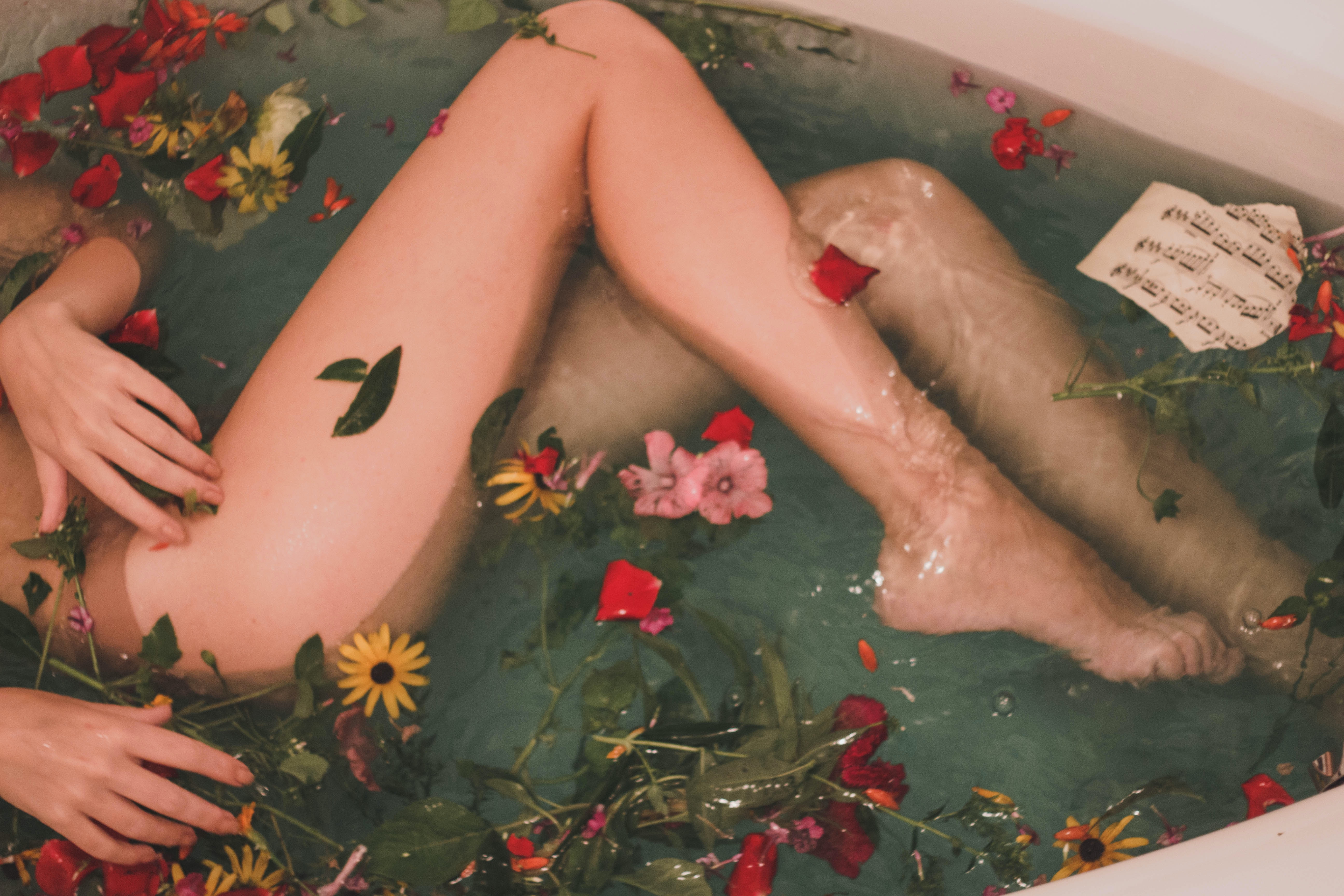 The lower body part / legs of a female in a bath.